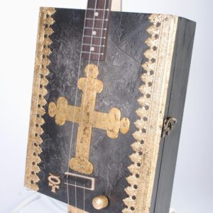 Closeup of cigar box guitar with gilded cross