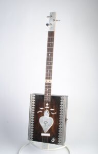 Cigar box guitar with milagros and hand cut aluminum burning heart