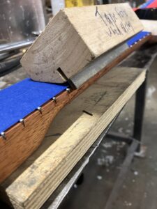 Guitar neck process. Shaving the fret ends