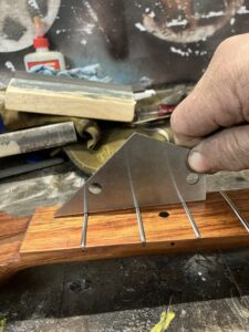 Guitar neck process. Checking the level of the frets