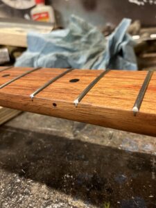 Guitar neck process. Frets almost finished