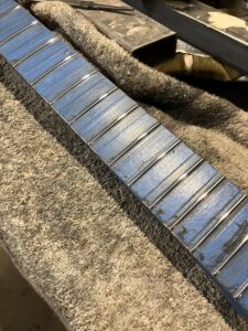 Guitar neck process. Frets finished and polished